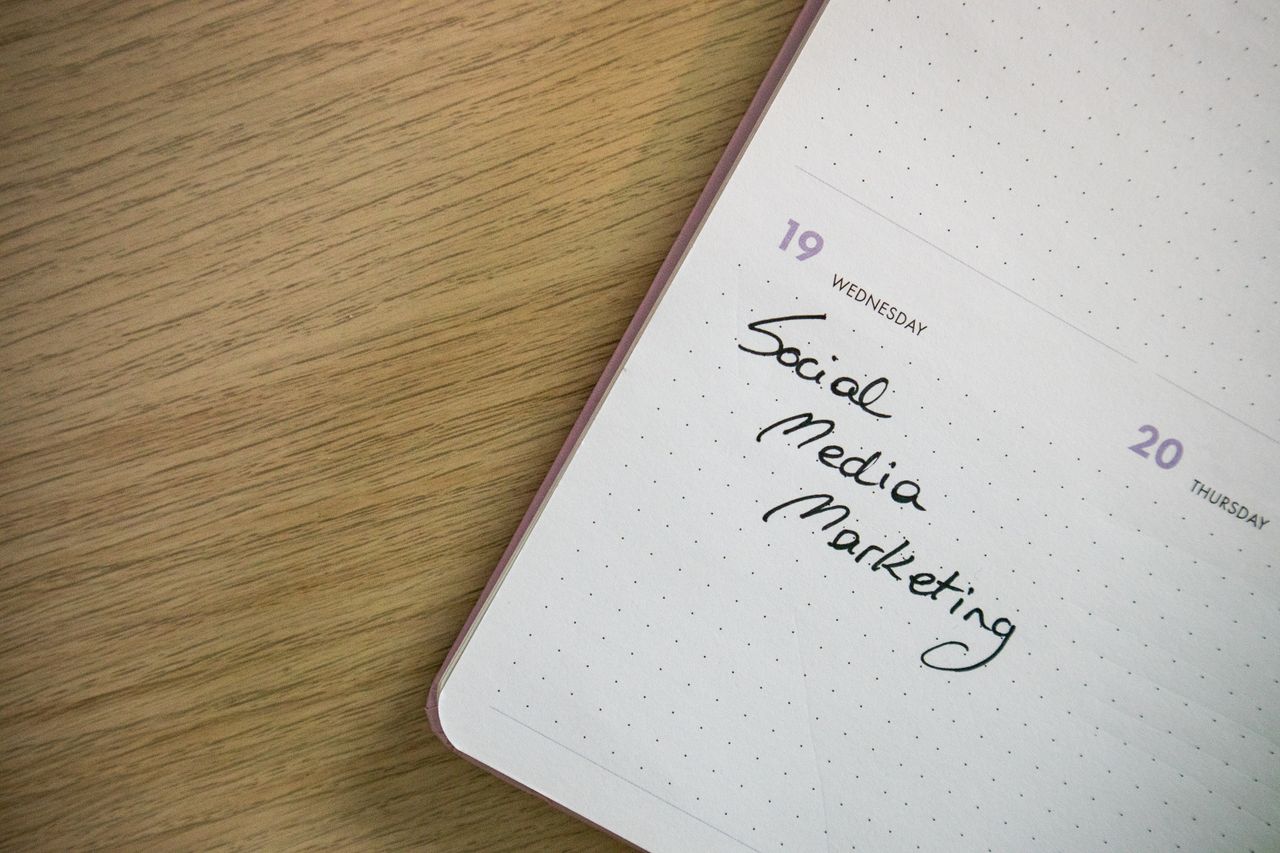 Close-up of a notebook page with Social Media Marketing handwritten on it.